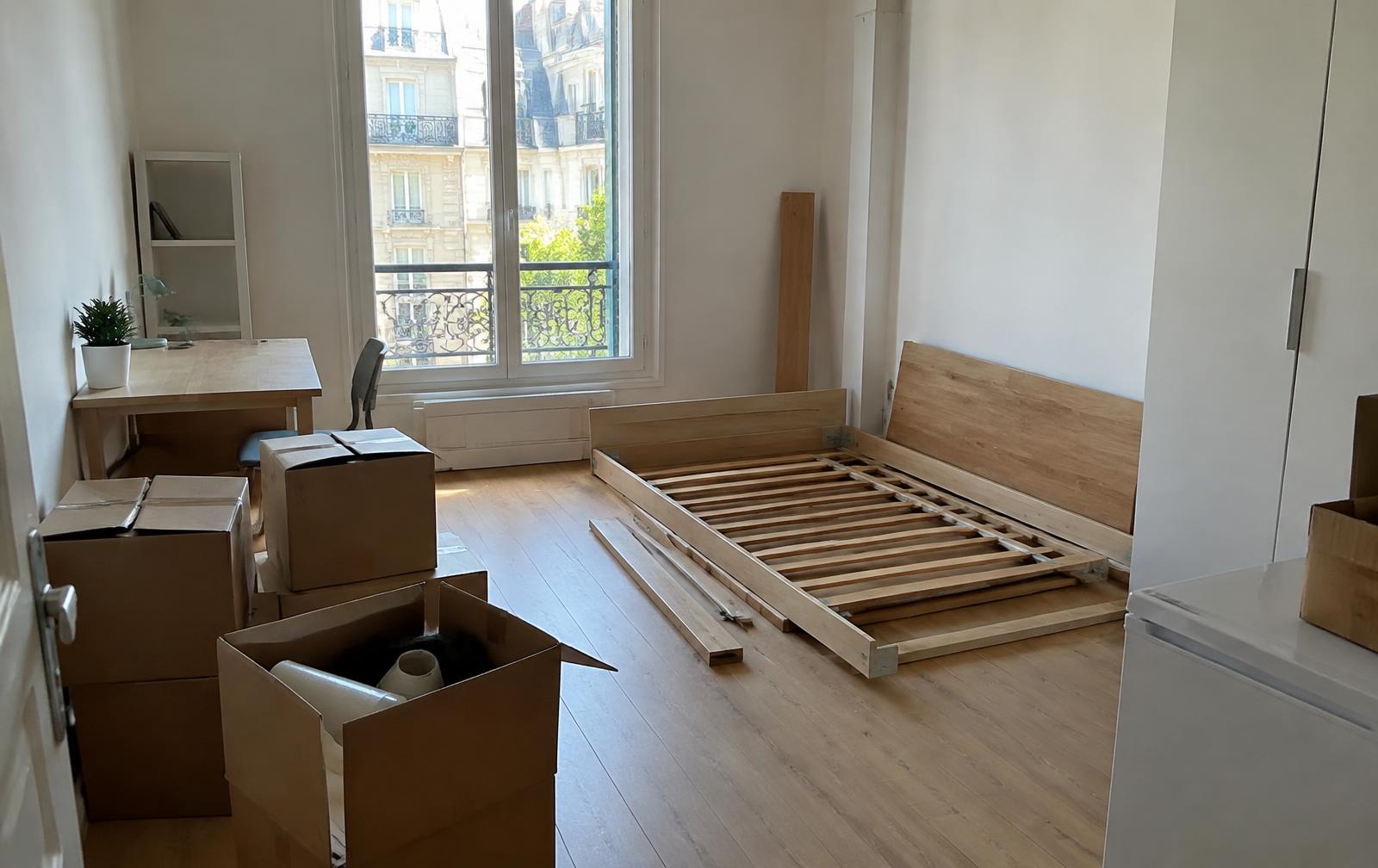 Studio étudiant en cours de déménagement, lit démonté et cartons